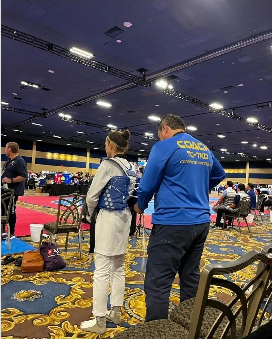 TC Taekwondo coach with a competition team athlete during a tournament