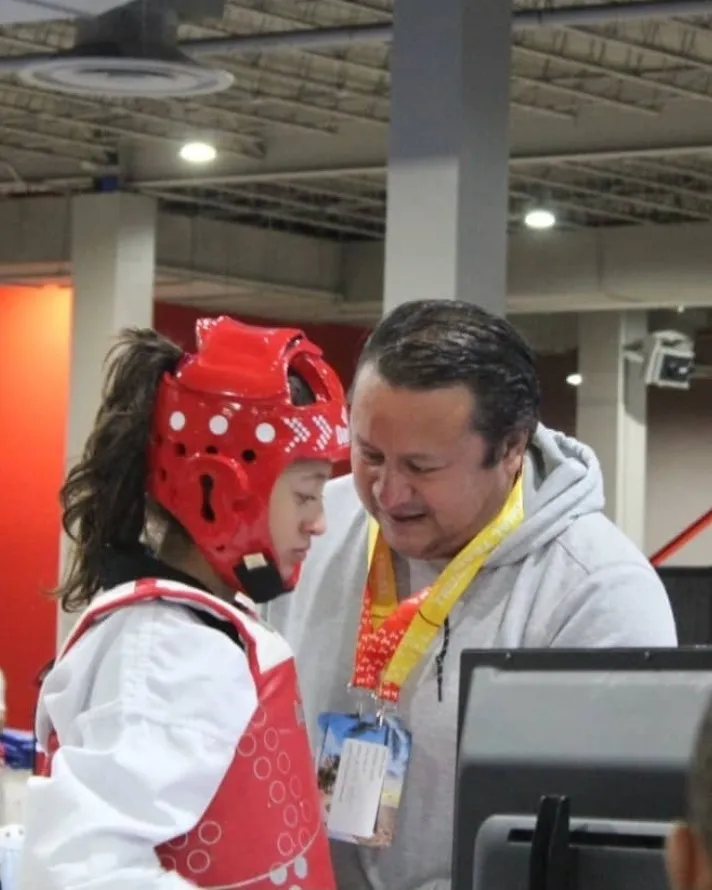 Master Castillo coaching an athlete during a competition